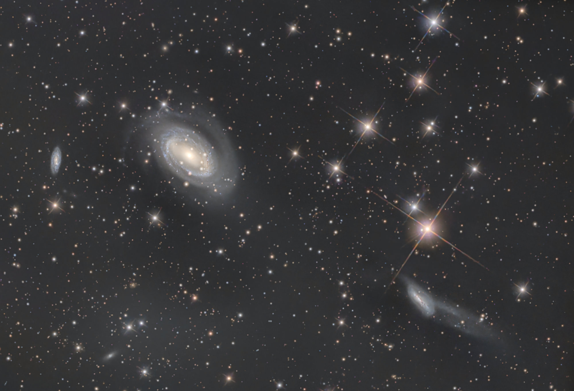 Das Holmberg-468-Galaxientriplett im Sternbild Coma Berenices enthält von links nach rechts die Galaxien NGC4712, NGC4725 und NGC4747. Die große Galaxie NGC 4725 interagiert mit der benachbarten Galaxie NGC 4747 rechts unten im Bild und besitzt ein extrem massereiches Schwarzes Loch im Zentrum.
